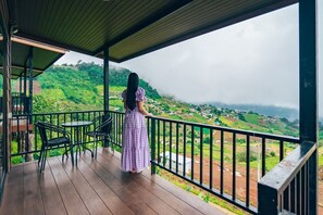 Enjoy breathtaking views of the surrounding hills and village from this balcony.