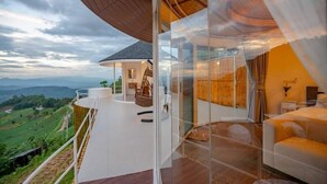 A modern, glass-enclosed balcony with a curved wooden ceiling, offering a scenic view of the countryside. - Mon Sai Lom Monjam (Mae Rim)