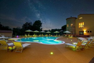 Una piscina al aire libre de temporada, sombrillas