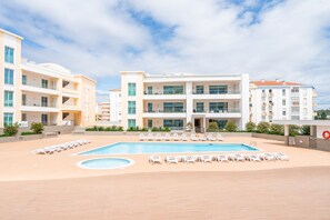 A modern building with a swimming pool and lounge chairs. - Lagos Marina View 4 With Pool by Homing (Lagos)