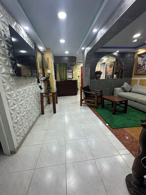 A hotel lobby with a reception desk, seating area, and a green carpet. - Private jacuzzi in the center of Santo Domingo (Santo Domingo)