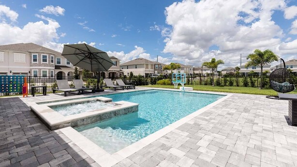 A swimming pool with a hot tub, lounge chairs, and a basketball hoop. - Luxury Retreat  7Bd Home - Close to Disney (Kissimmee)