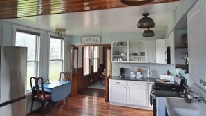 A kitchen with white cabinets, a dining table with chairs, and a wooden ceiling. - Historic Whiffletree place, 4br, riverview, no neighbors (Sparland)