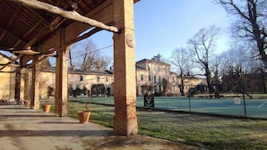 A covered outdoor area with brick pillars, a bench, and potted plants. - AGRITURISMO LE CORTI DELLA GUALDANA (Voghera)