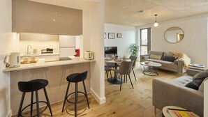 A modern apartment with a kitchen, dining area, and living room.