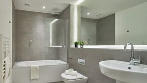 A modern bathroom with a bathtub, toilet, and sink. - Lucky Strike in Manchester (Manchester)