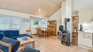 A cozy living room with a sofa and chairs, a dining area with a table and chairs, and a kitchen with a stove and cabinets. - 4 Star Holiday Home in Ottendorf (Otterndorf)