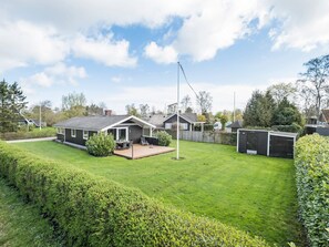 A residential property with a well-maintained lawn, a patio area, and a garage.