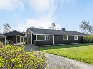 A single-story house with a garage, a covered porch, and a well-maintained lawn. - 4 Star Holiday Home in Sydals (Sydals)