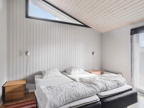 A bedroom with a bed, bedside tables, a window, and a view of the outdoors. - 4 Star Holiday Home in Sydals (Sydals)