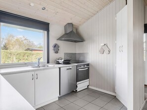 A modern kitchen with a large window, a built-in oven, and a stove. - 4 Star Holiday Home in Sydals (Sydals)