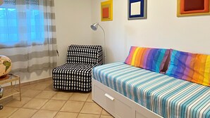 Une chambre à coucher avec un lit, une chaise, une lampe et un globe terrestre posé sur une table de chevet.