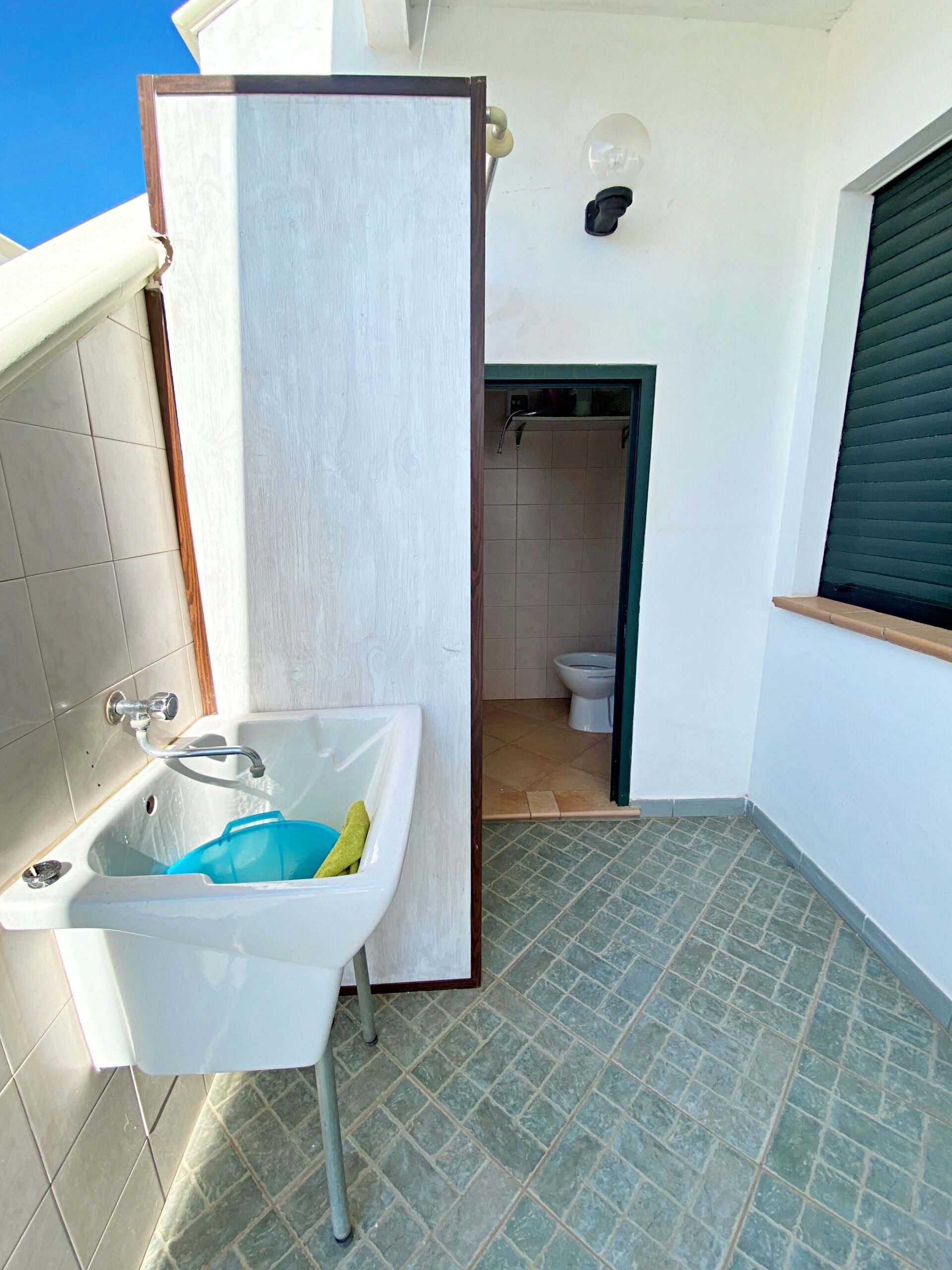 Un baño pequeño con lavamanos, ducha e inodoro.