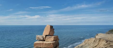 A stack of stones by the sea with a clear view of the ocean.
