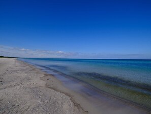 En strand med klart vatten och en bred sandstrand.