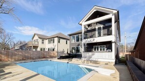 A modern two-story house with a swimming pool in the backyard.