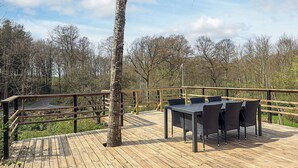 A wooden deck with a table and chairs, surrounded by a railing and trees. - 6 Person Holiday Home in Asperup (Middelfart)
