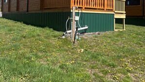 Una cabaña de madera con un porche y un patio cercado.