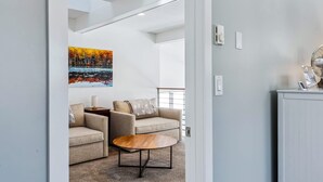Una sala de estar moderna con un conjunto de sofá, una mesa de centro y un cuadro en la pared.