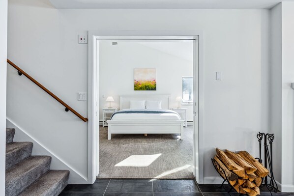 Un dormitorio moderno con una cama, mesitas de noche y un cuadro.