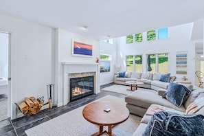 A spacious living room with a fireplace, a sofa set, and a coffee table.