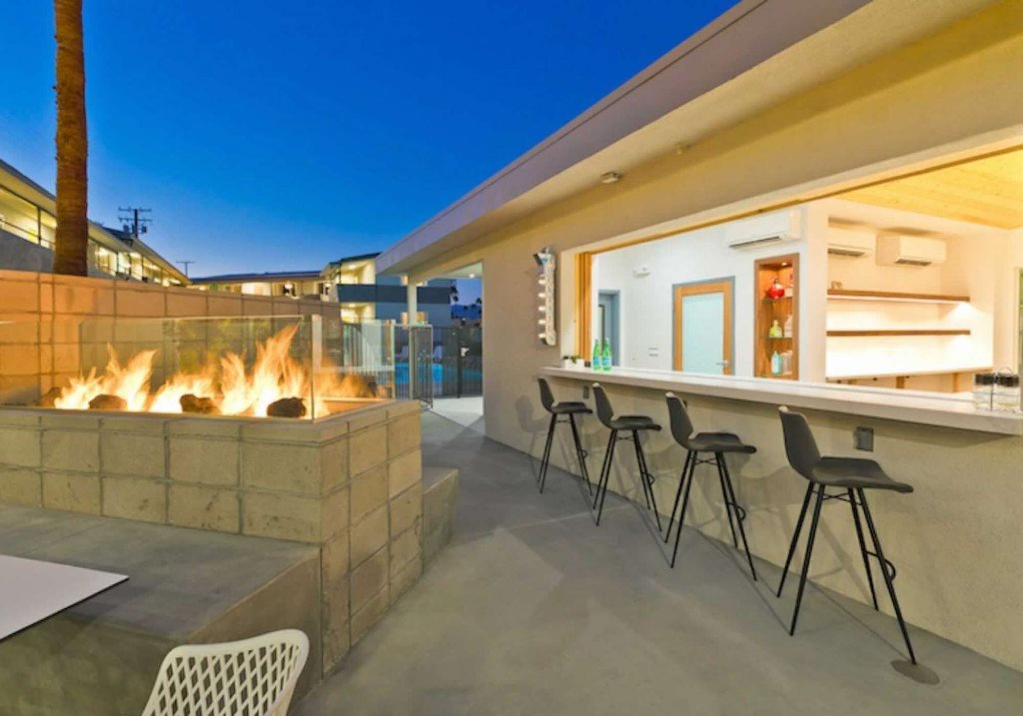 An outdoor bar area with a fire feature and bar stools.