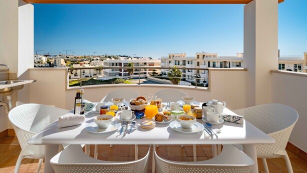 A breakfast setup on a balcony with a clear view of the cityscape. - Lagos Ocean View 2 With Pool by Homing (Lagos)