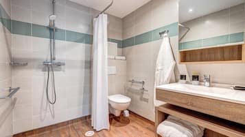 A modern bathroom with a shower, toilet, and vanity.