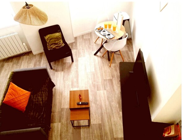 Relax in this cozy space with a sofa, dining table, and mounted TV.