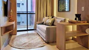 Una sala moderna con un sofá, una mesa de centro y un televisor de pantalla plana.