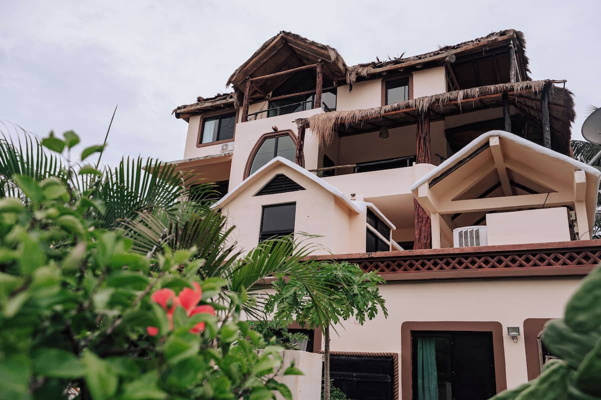 Ein mehrstöckiges Gebäude im traditionellen Baustil, mit einem Reetdach und einem Balkon.