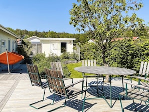 A wooden deck with outdoor furniture, a small building, and a tree. - 4 Star Holiday Home in Stenungsund (Stenungsund)