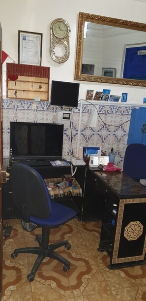 A room with a desk, computer, chair, and a large mirror. - aline hostel (Chefchaouen)