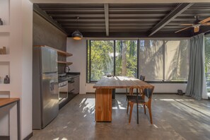 Enjoy cooking in this spacious kitchen with a large island, stainless steel appliances, and a window offering views of the surrounding trees.