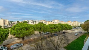A residential area with apartment buildings, a road, and trees. - Cozy Home by the Sea (Le Grau-du-Roi)