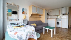 A compact living space with a dining area, a sofa, a small table, and a kitchenette. - Cozy Home by the Sea (Le Grau-du-Roi)