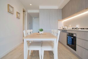 Enjoy meals in the kitchen with oven and dishwasher, and dine at the wooden table with four chairs.