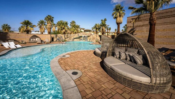 A swimming pool with lounge chairs and a wicker seating area. - Oasis In The California Desert | Pool. Adults Only (Palm Springs)