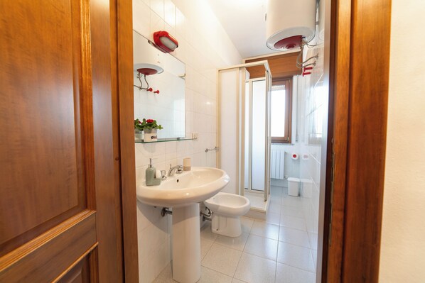 Une salle de bain moderne avec un lavabo, un bidet et une douche à parois de verre.
