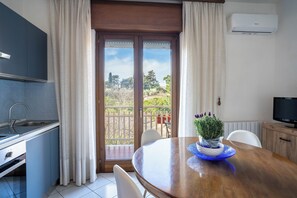 Une cuisine équipée d’un évier, de placards et d’un coin repas avec une table et des chaises.