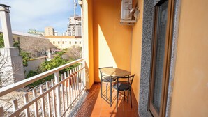 A balcony with a table and chairs, a railing, and a window. - Casa Wanda Appartamento il Mirto (Oristano)