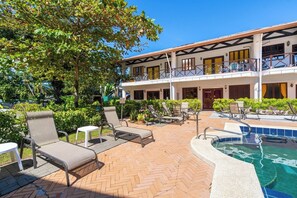 A hotel with a pool area, outdoor seating, and a two-story building with balconies. - Villa Spring#5 w/ Pool close to Evething in Manuel Antonio (Quepos)