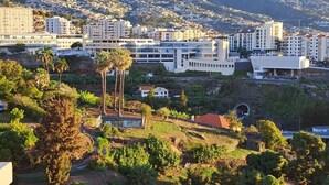 Una zona residencial con edificios modernos, una construcción blanca destacada y abundante vegetación.