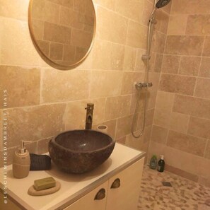 A bathroom with a round mirror, a vessel sink, a handheld showerhead, and a tiled floor. - Les Chemins d'Ambre & Thaïs: Charming dwelling in the heart of the Nantes vineyards (La Regrippière)