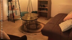 Un salon chaleureux avec une table ronde, un canapé, une bibliothèque et une échelle.