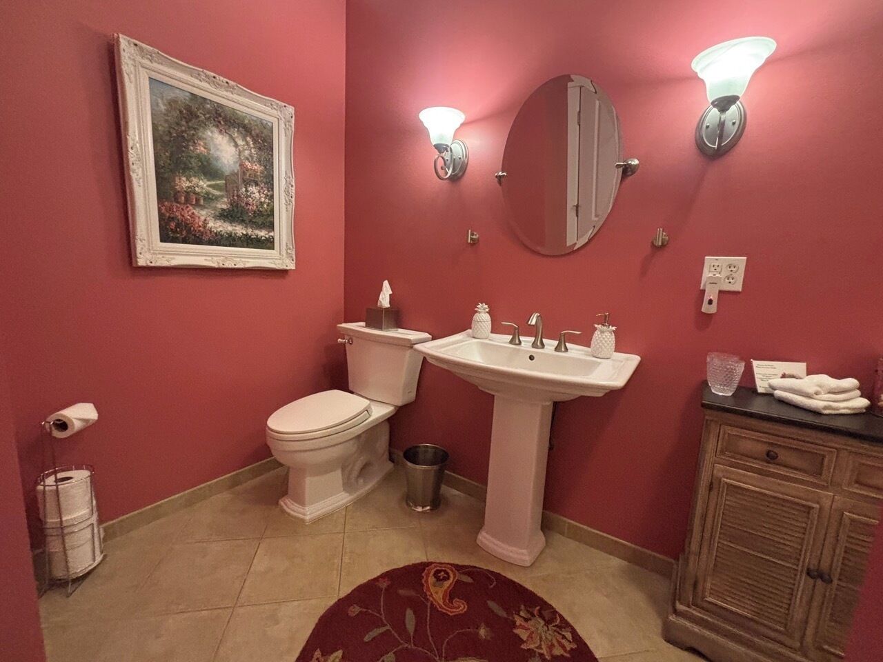 A bathroom with a toilet, sink, and cabinet.