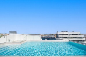 A rooftop swimming pool with a clear view of the surrounding buildings and clear sky. - Lagos Modern 2 With Pool by Homing (Lagos)