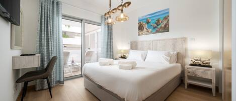 Quarto de hotel moderno com uma cama grande, uma escrivaninha e uma cadeira.