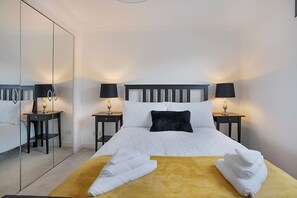 2 habitaciones, escritorio y tabla de planchar con plancha