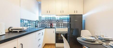 Een koelkast, een oven, een kookplaat, een koffiezetapparaat/waterkoker